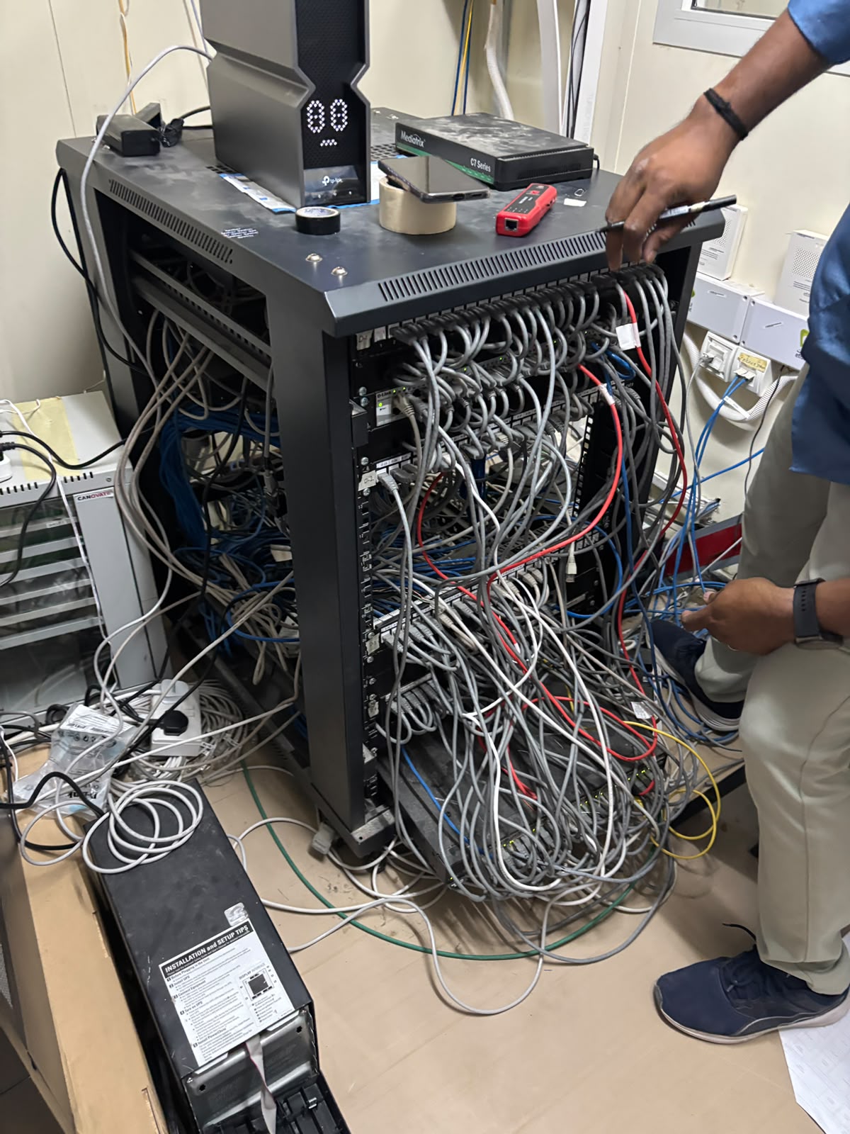 The main network cabinet before the project, with tangled and unlabeled cables